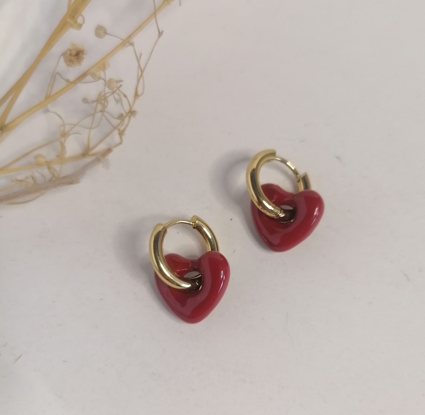 AD033 | Aros en acero dorado con corazón en resina roja