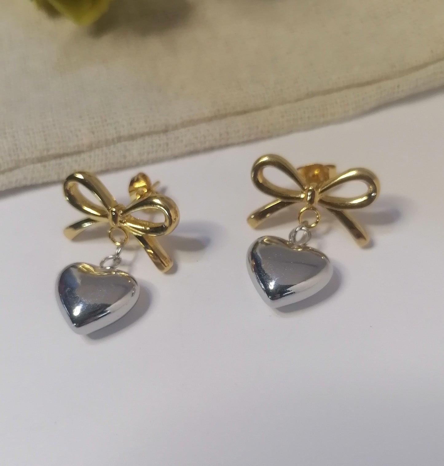 AQ037 | Aros con lazo y corazón en acero combinado