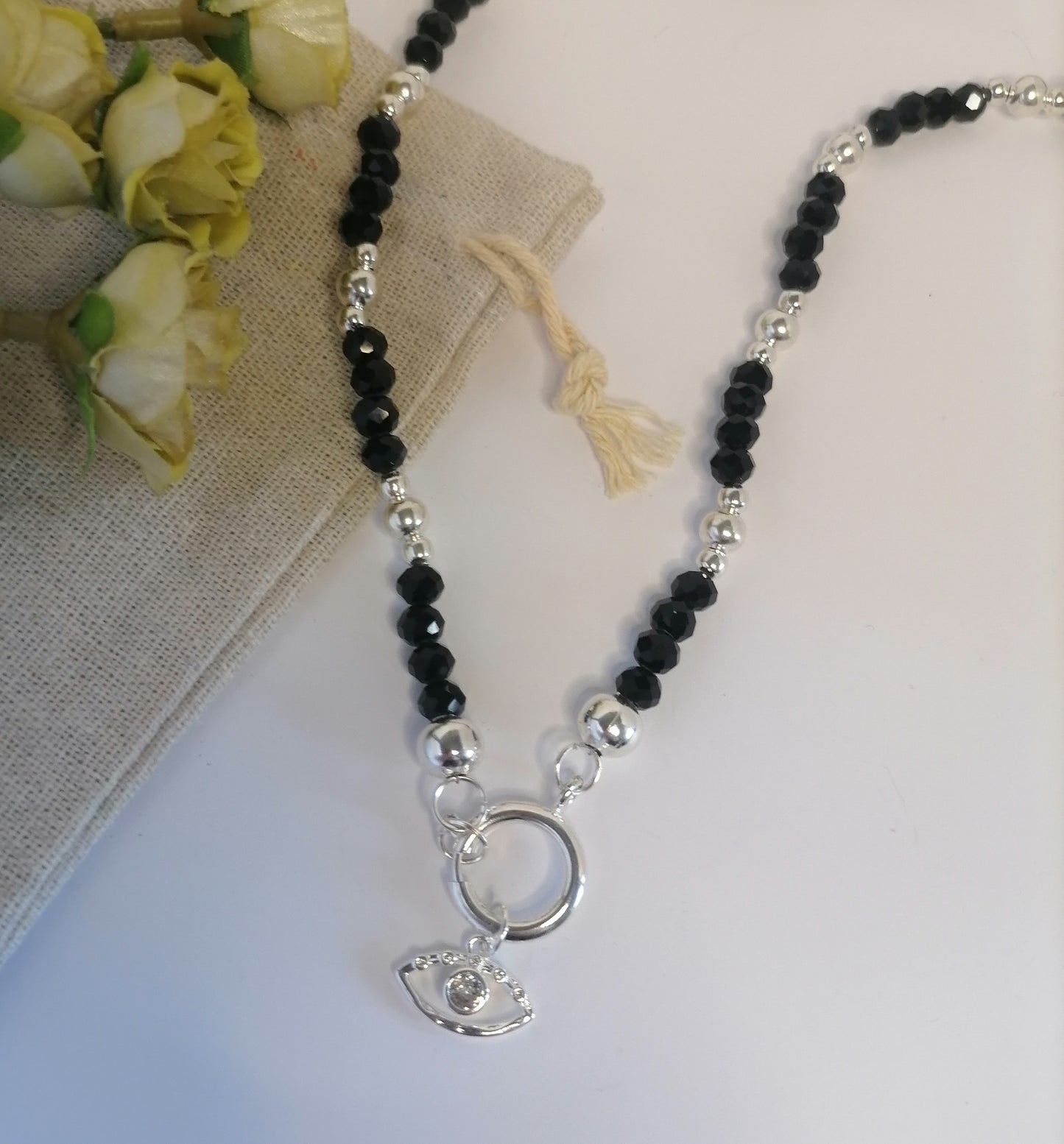 CQ021 | Collar de cuentas negro brillante con cierre marinero y dije ojo en acero blanco
