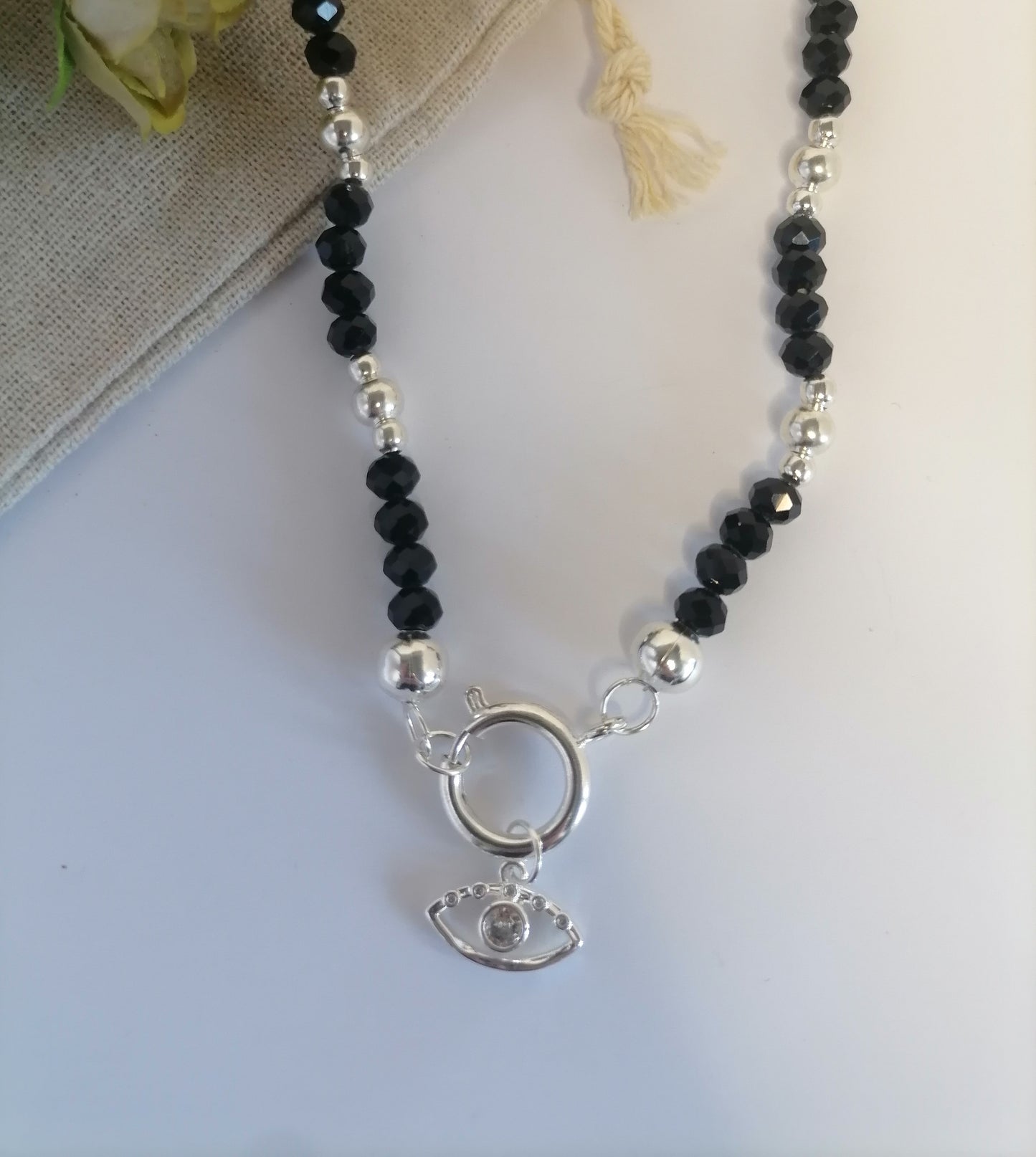 CQ021 | Collar de cuentas negro brillante con cierre marinero y dije ojo en acero blanco